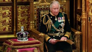 Prince Charles, Prince of Wales reads the Queen's speech next to her Imperial State Crown
