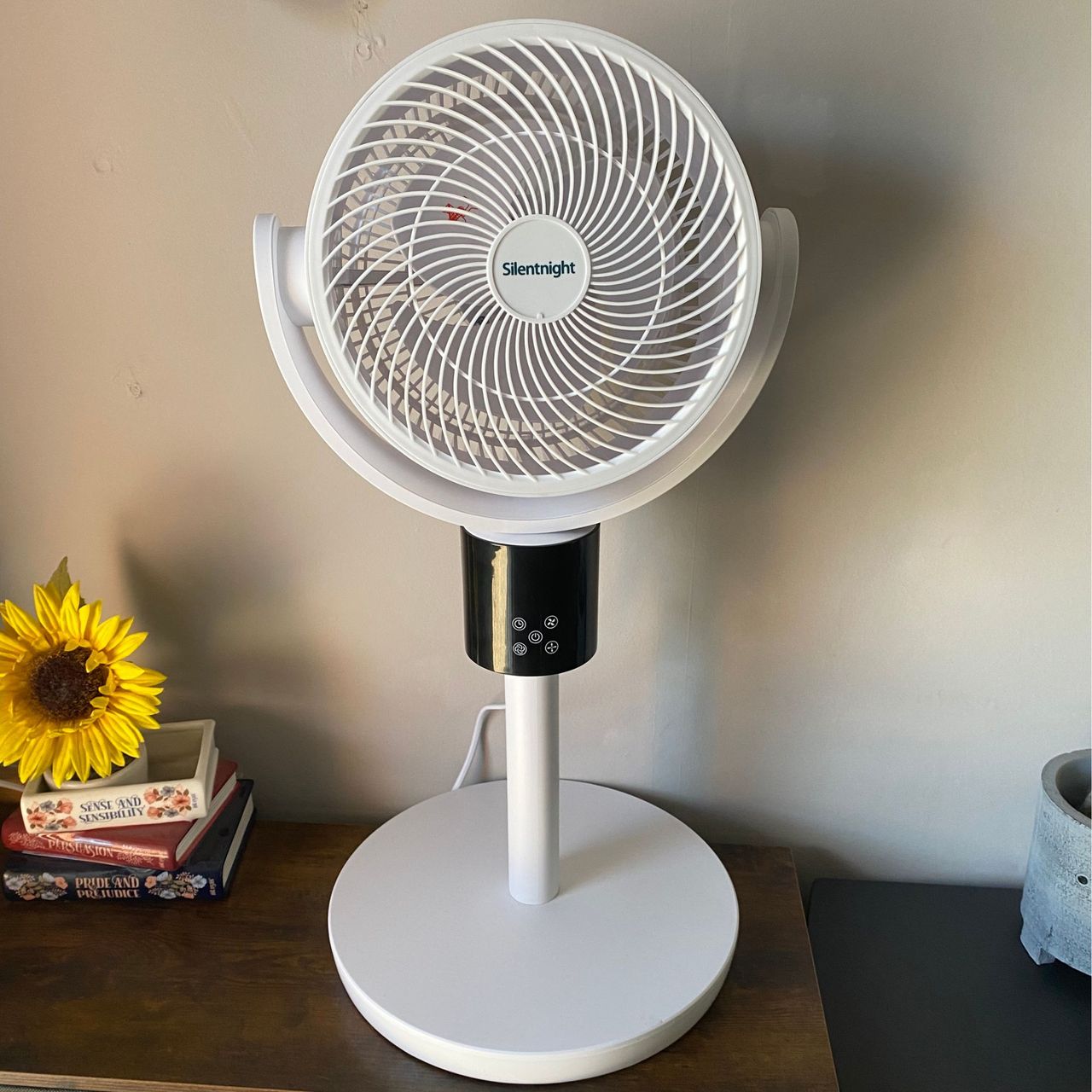 Silentnight Airmax Pro360 Pedestal Fan in desktop configuration on a wooden sideboard in front of a neutral wall