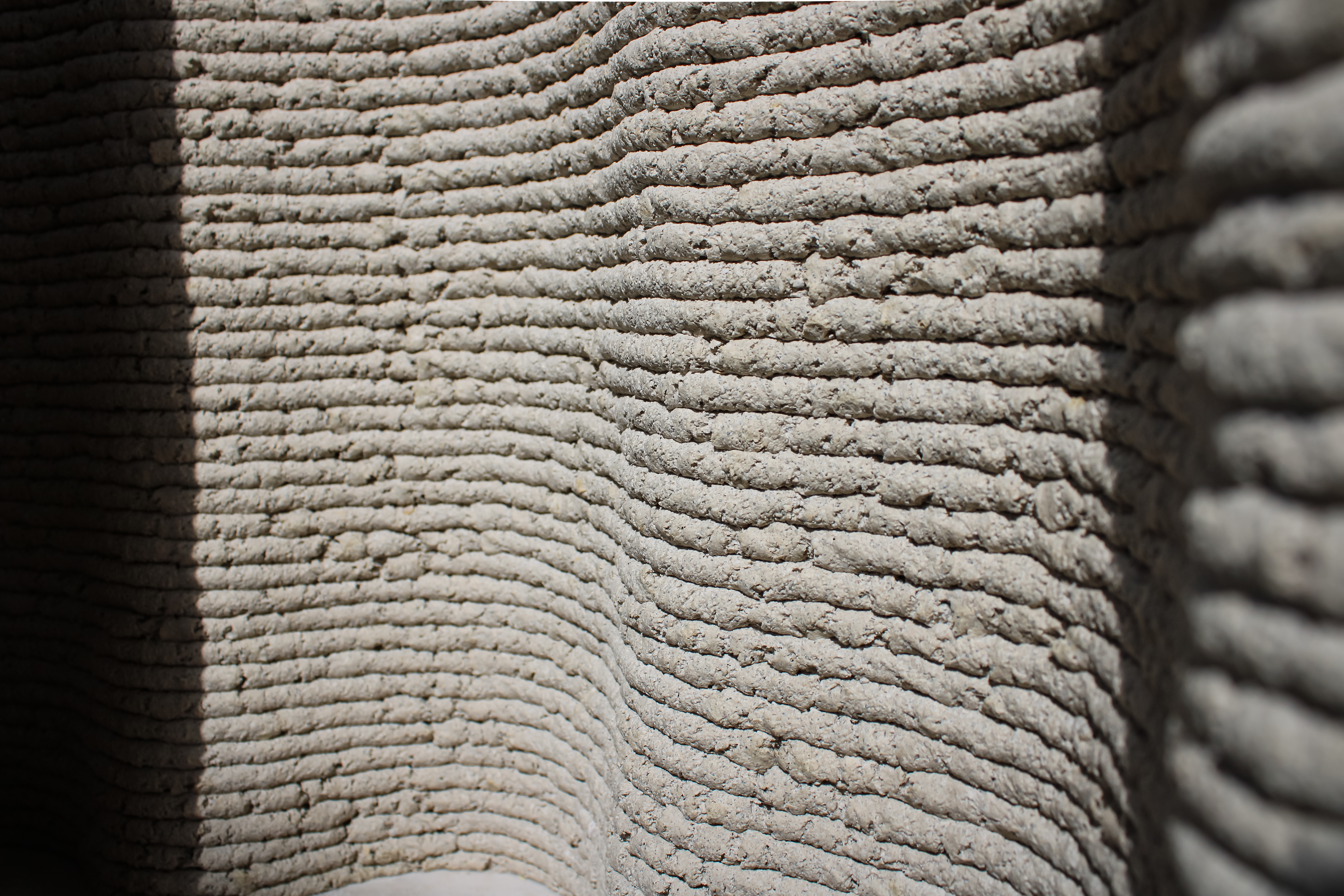 the wavy textured surface of a wall made of Corncretl, a corn based bio material alternative to concrete which has been 3D printed