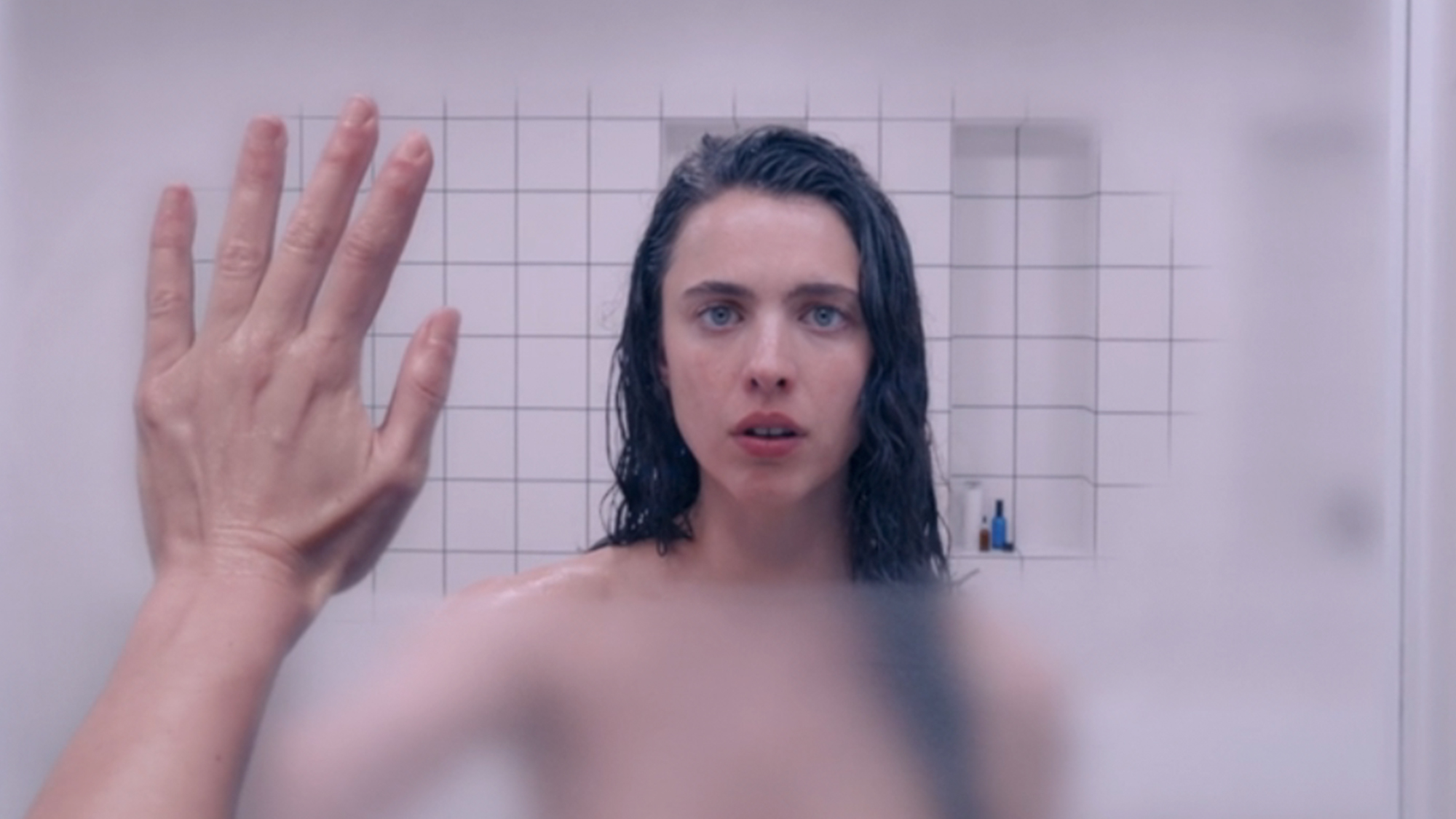 Margaret Qualley wiping the steam from a mirror in the Substance.