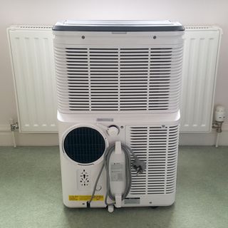 The AEG Comfort 6000 Portable Air Conditioner being tested in a room with green carpet