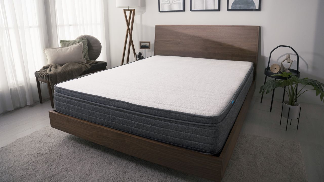 The Origin Hybrid Mattress on a wood frame bed in a modern bedroom