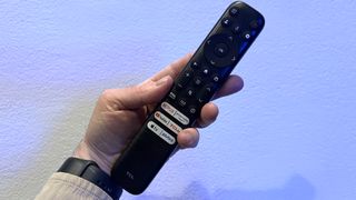 TCL QM851G remote control held in hand