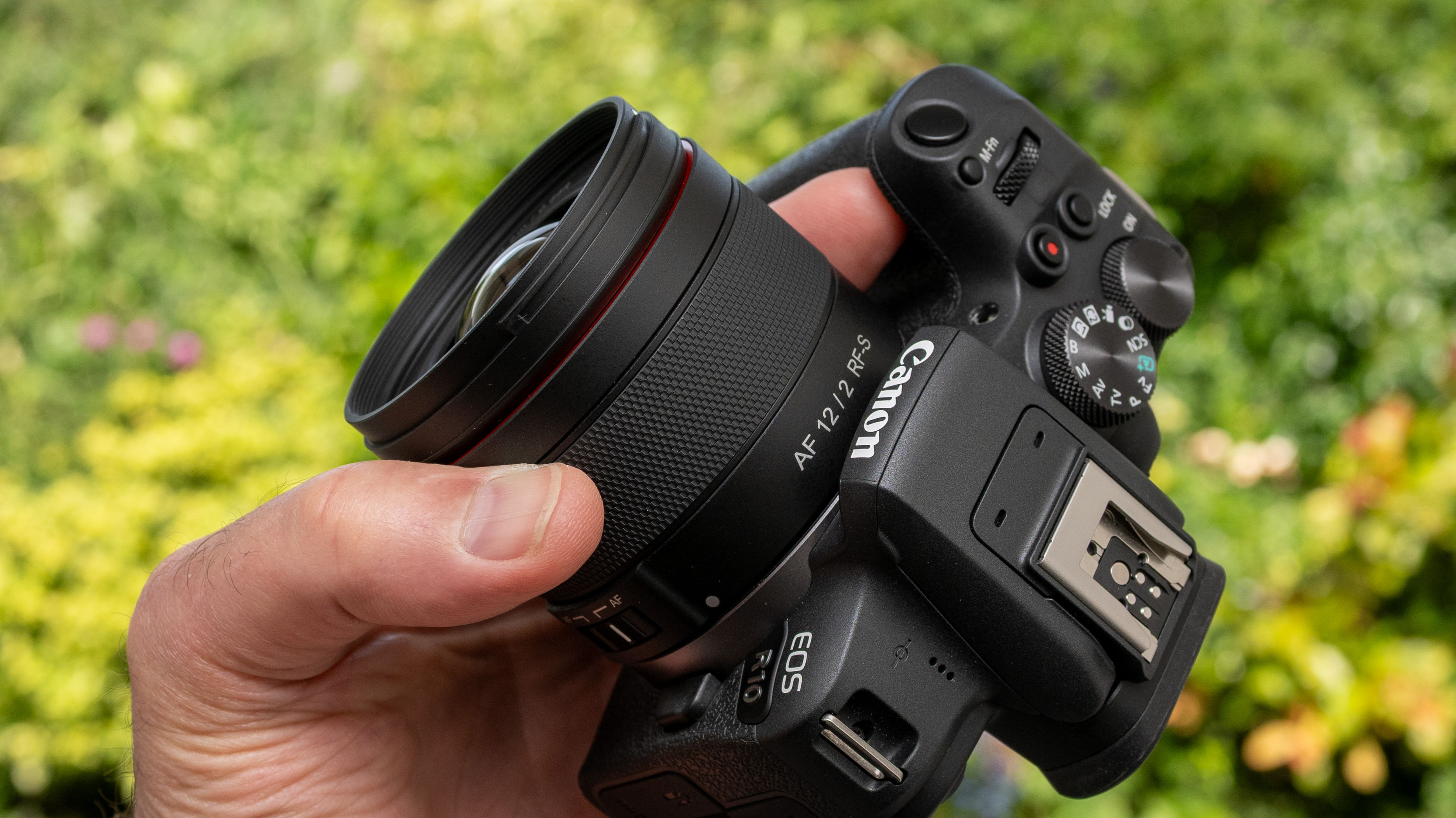 LK Samyang AF 12mm f/2 RF-S product shot lens held in hand