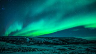 An aurora glows in skies over Iceland.