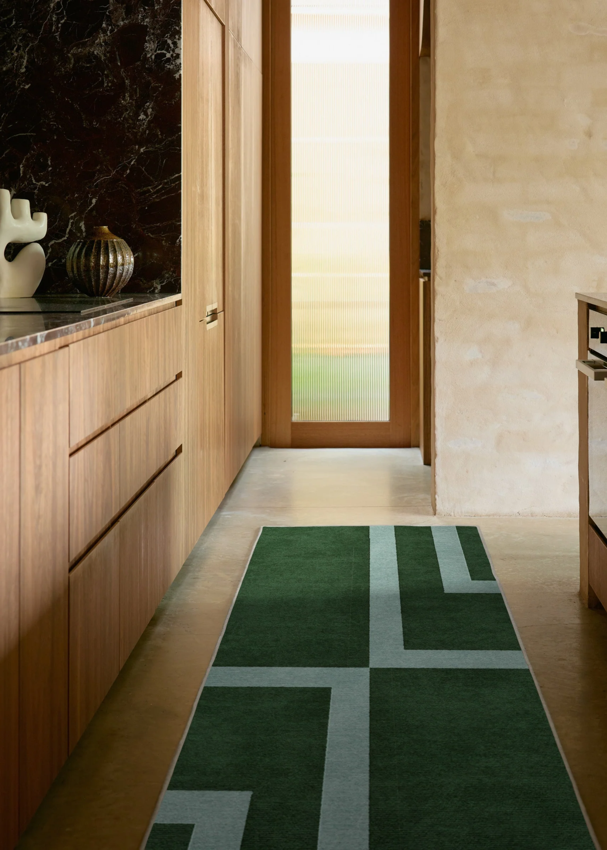 A kitchen with a mint and deep green runner rug