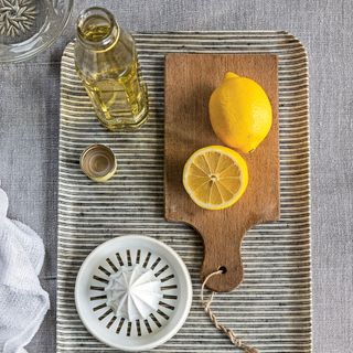 lemons on wooden board and bottle of cleaner