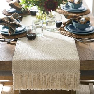 Handwoven Basketweave Cotton Fringe Table Runner on a dining table.