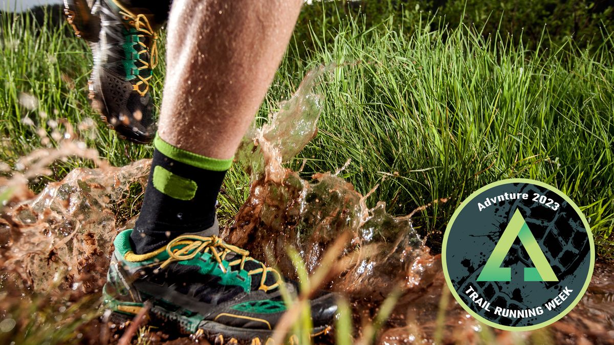 Close-up of person&#039;s feet running through muddy puddle