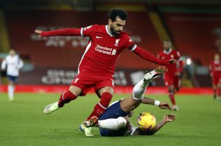 Liverpool forward Mohamed Salah skips past a Tottenham defender