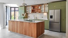 A kitchen with wooden cabinets and green features 