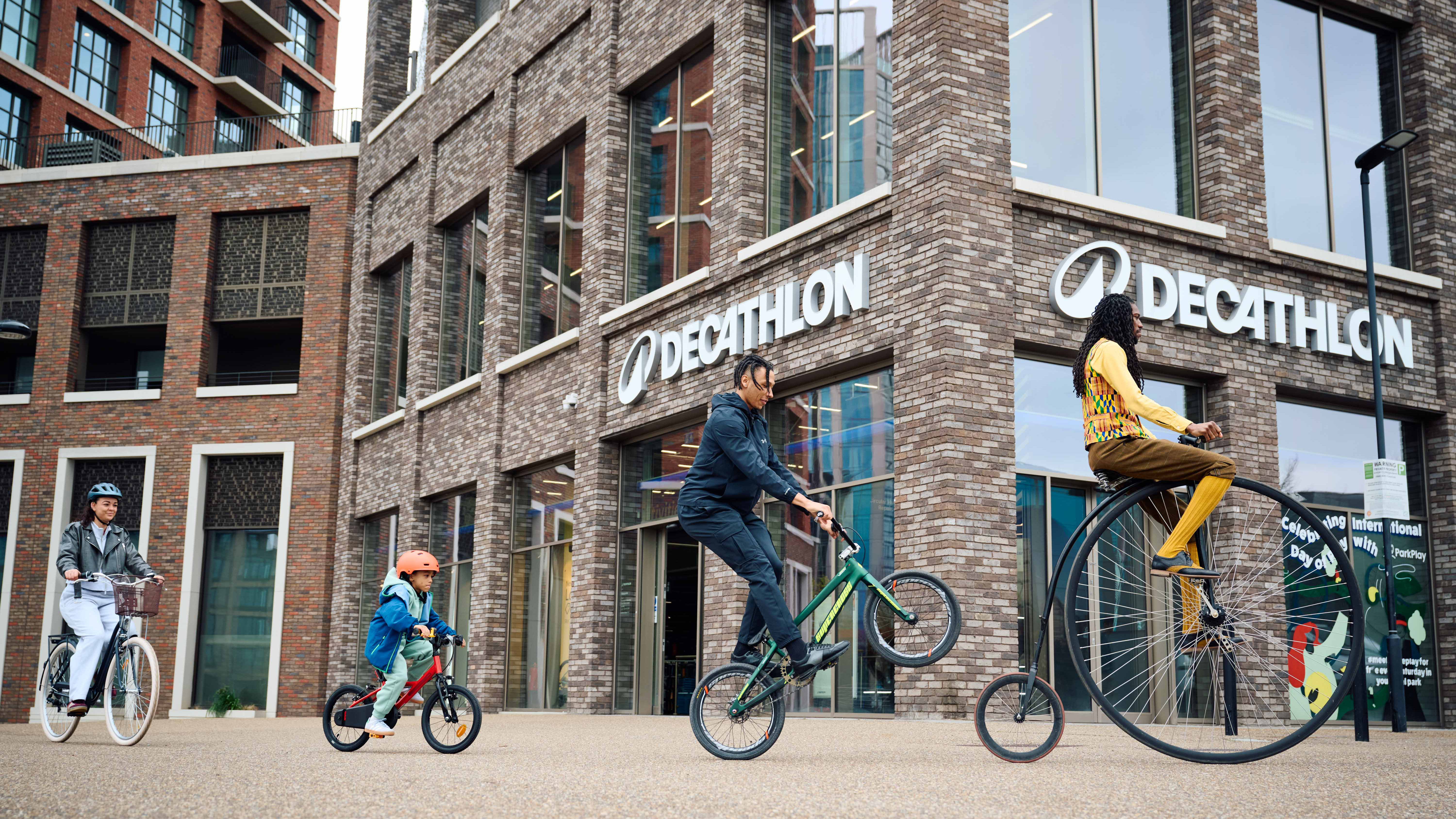 Cyclists ride past a Decathlon store