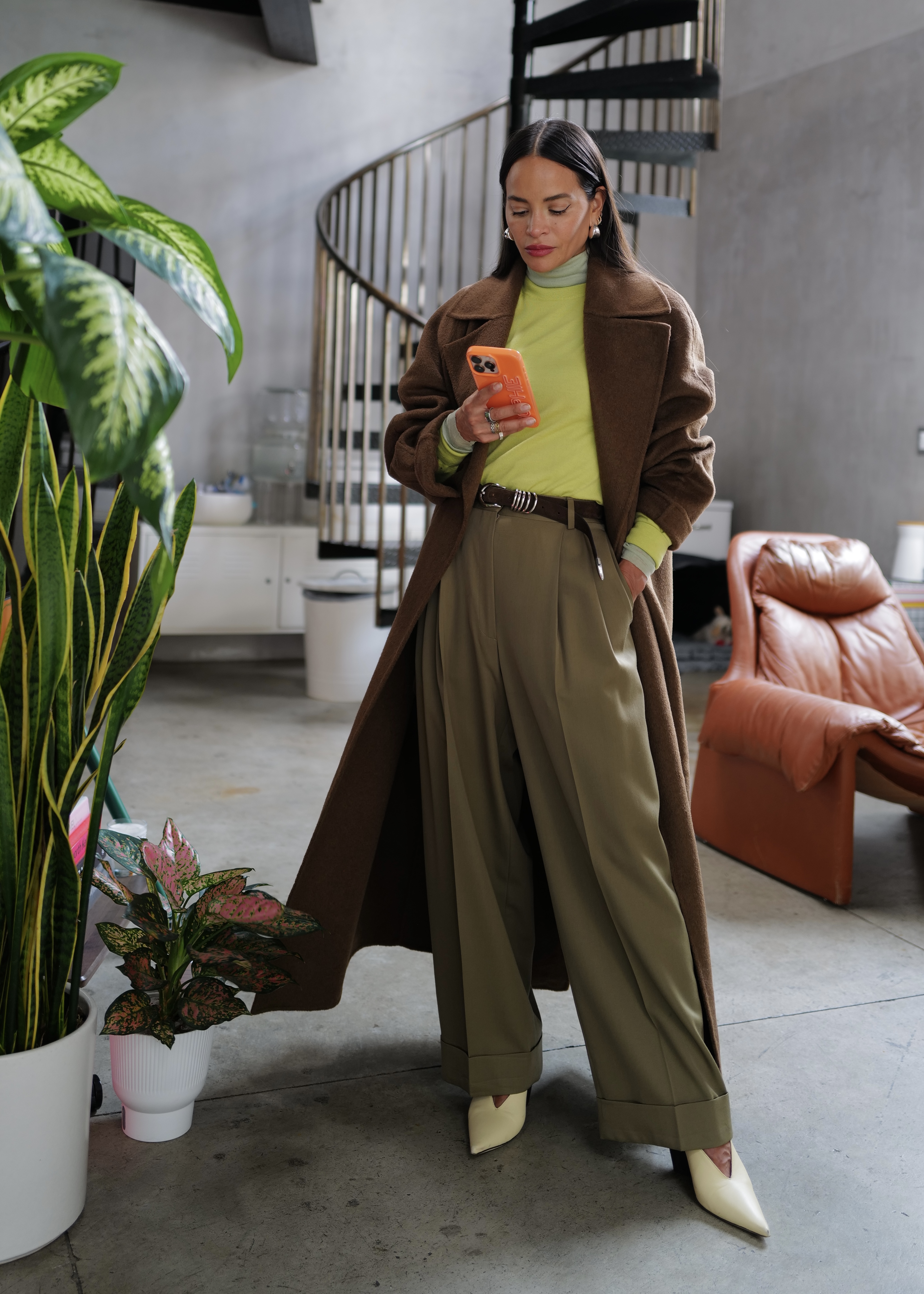 Sophie Lopez wearing a green shirt, a brown coat, and khaki pants