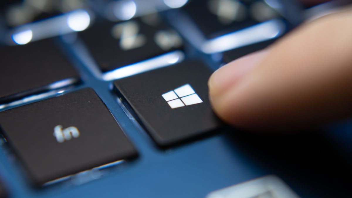 Fingertip pressing keyboard key with Windows logo on it