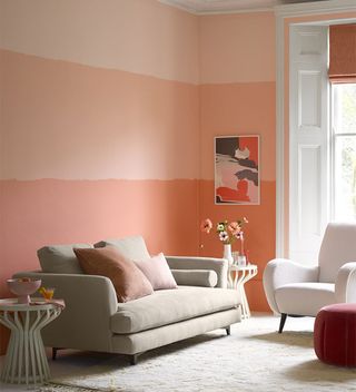 peach ombre effect wall in living room with cream sofa