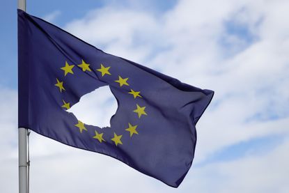 An EU flag flies with a hole in it