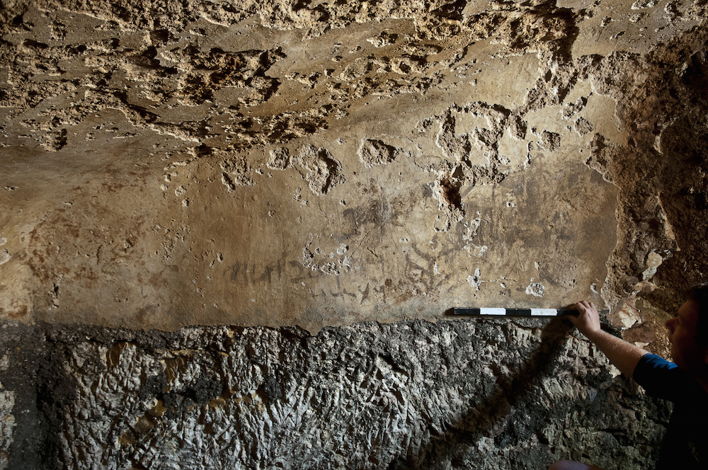 The writing on the wall of the bath is Hebrew script, but the words are Aramaic.