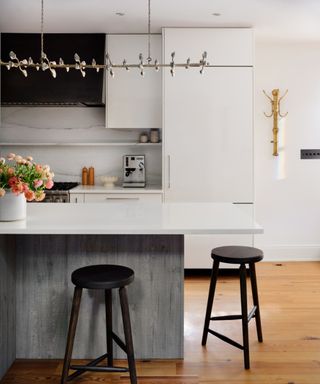 A white kitchen with a statement light fixture above the island