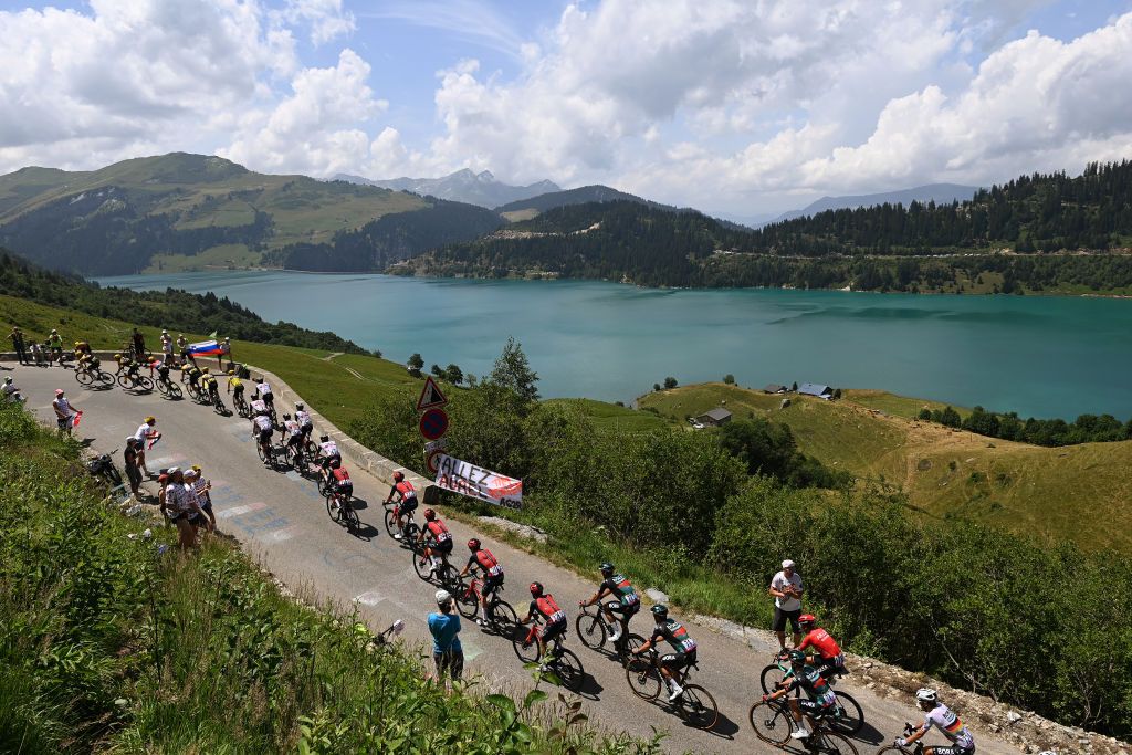COURCHEVEL FRANCE JULY 19 Jonas Vingegaard of Denmark and Team JumboVisma Yellow Leader Jersey Tadej Pogacar of Slovenia and UAE Team Emirates White Best Young Rider Jersey and a general view of the peloton passing close to the Roselend Dam 1971m during the stage seventeen of the 110th Tour de France 2023 a 1657km at stage from SaintGervais MontBlanc to Courchevel UCIWT on July 19 2023 in Courchevel France Photo by Tim de WaeleGetty Images
