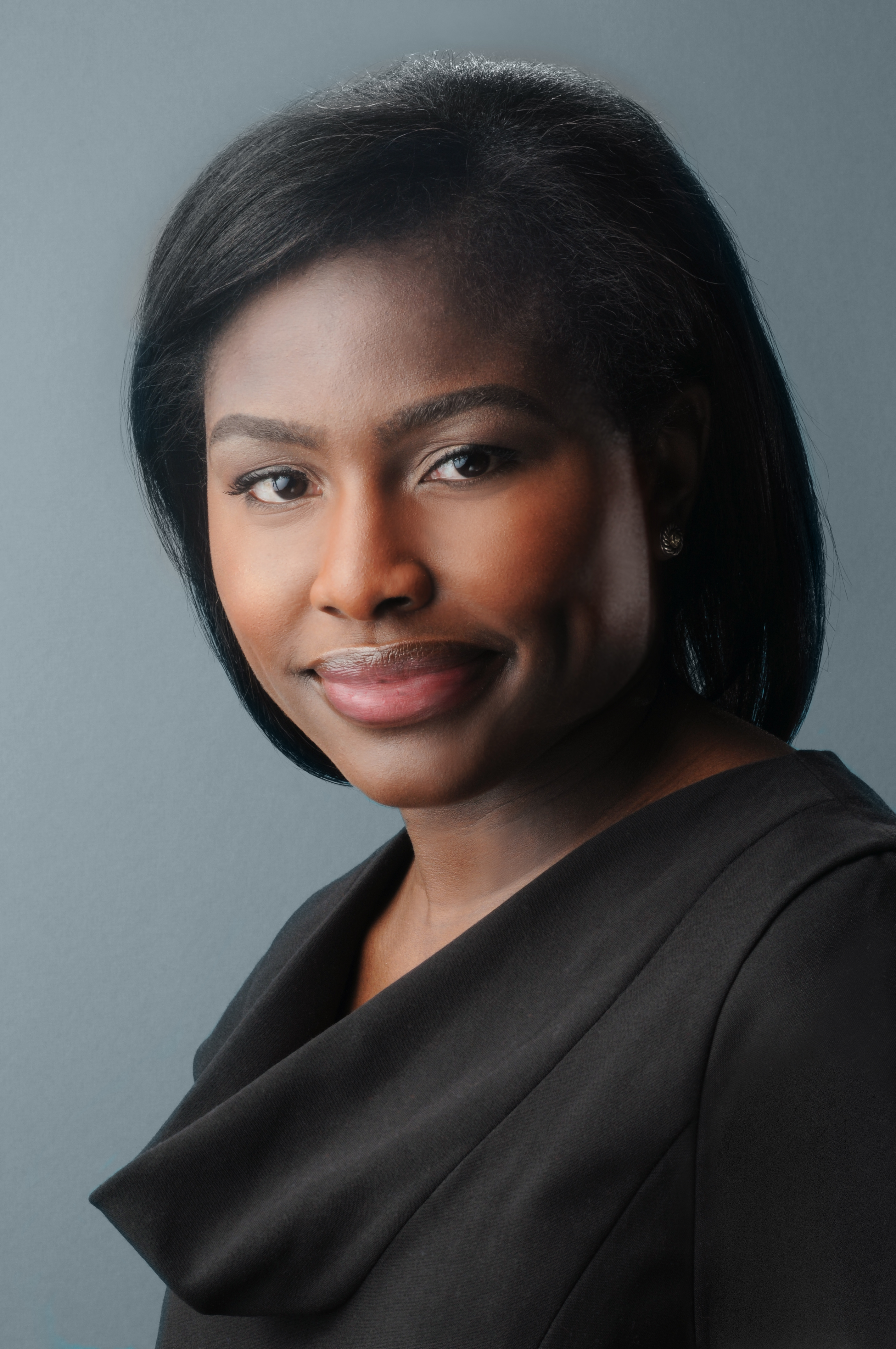 a black woman with a bob in a black top smiling at the camera