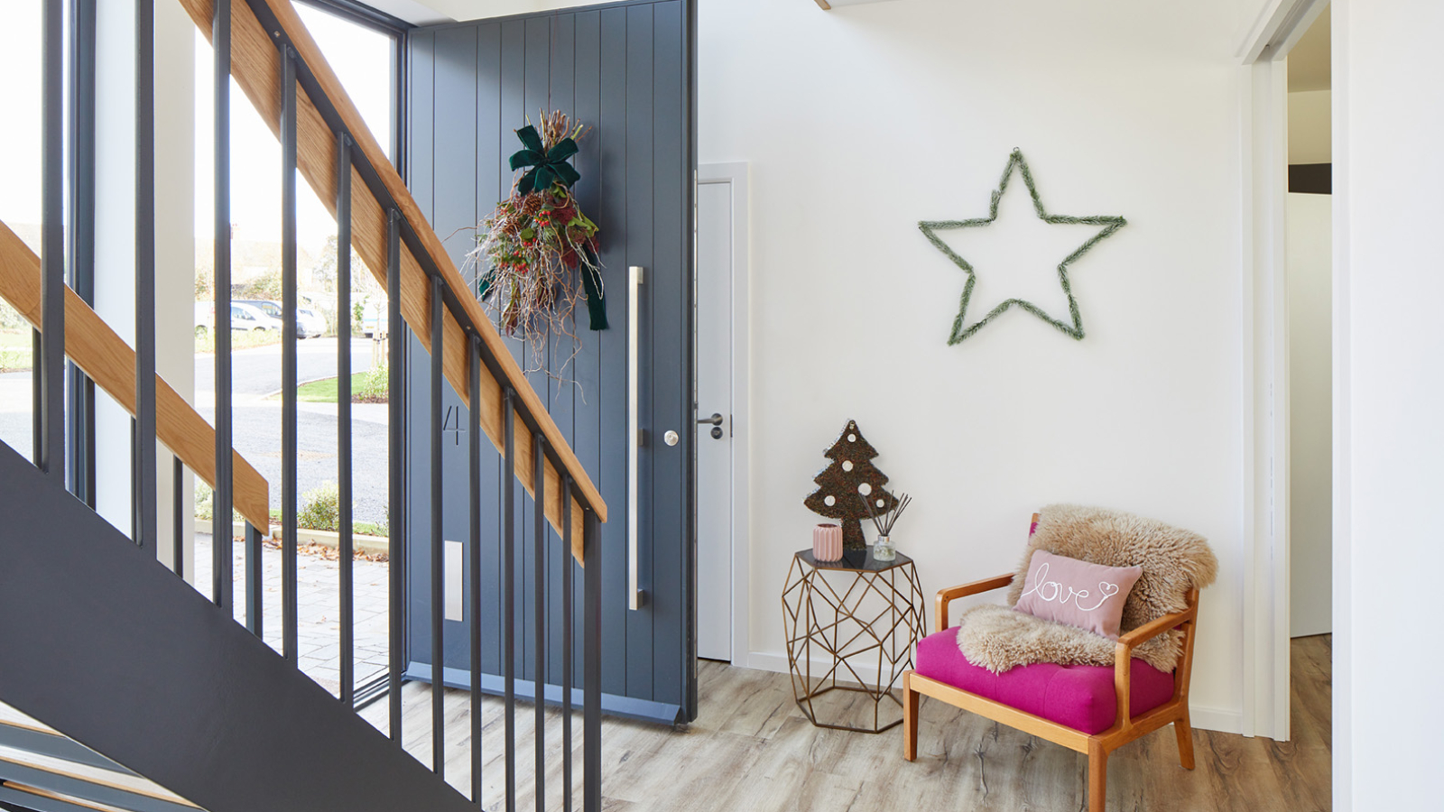 inside of hallway with large modern grey door open with Xmas wreath