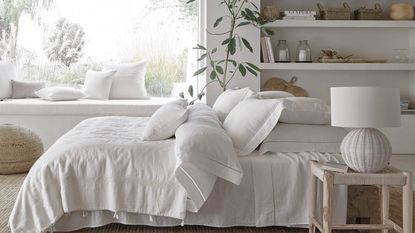 linen bed sheets in a scandi inspired boho bedroom with rattan accessories and furniture - the white company
