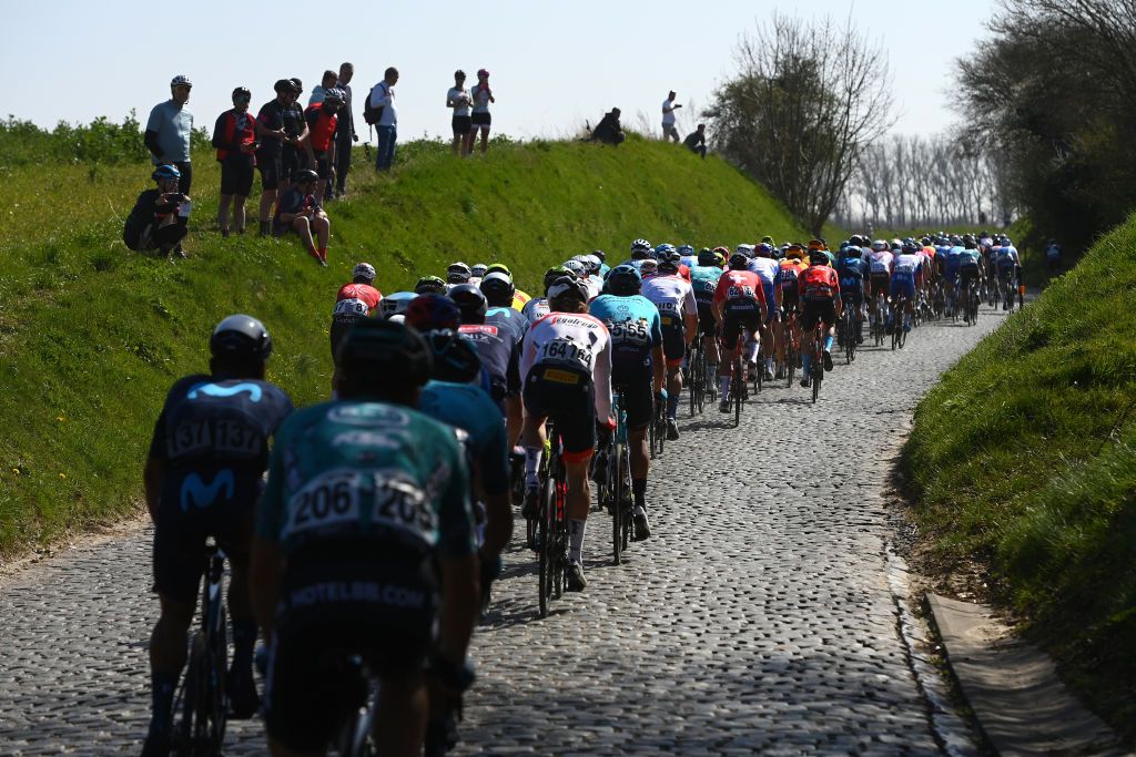 HARELBEKE BELGIUM MARCH 25 The peloton passing through Oudenaarde Ename cobblestones sector while fans cheer during the 65th E3 Saxo Bank Classic 2022 a 2039km one day race from Harelbeke to Harelbeke E3SaxobankClassic WorldTour on March 25 2022 in Harelbeke Belgium Photo by Tim de WaeleGetty Images