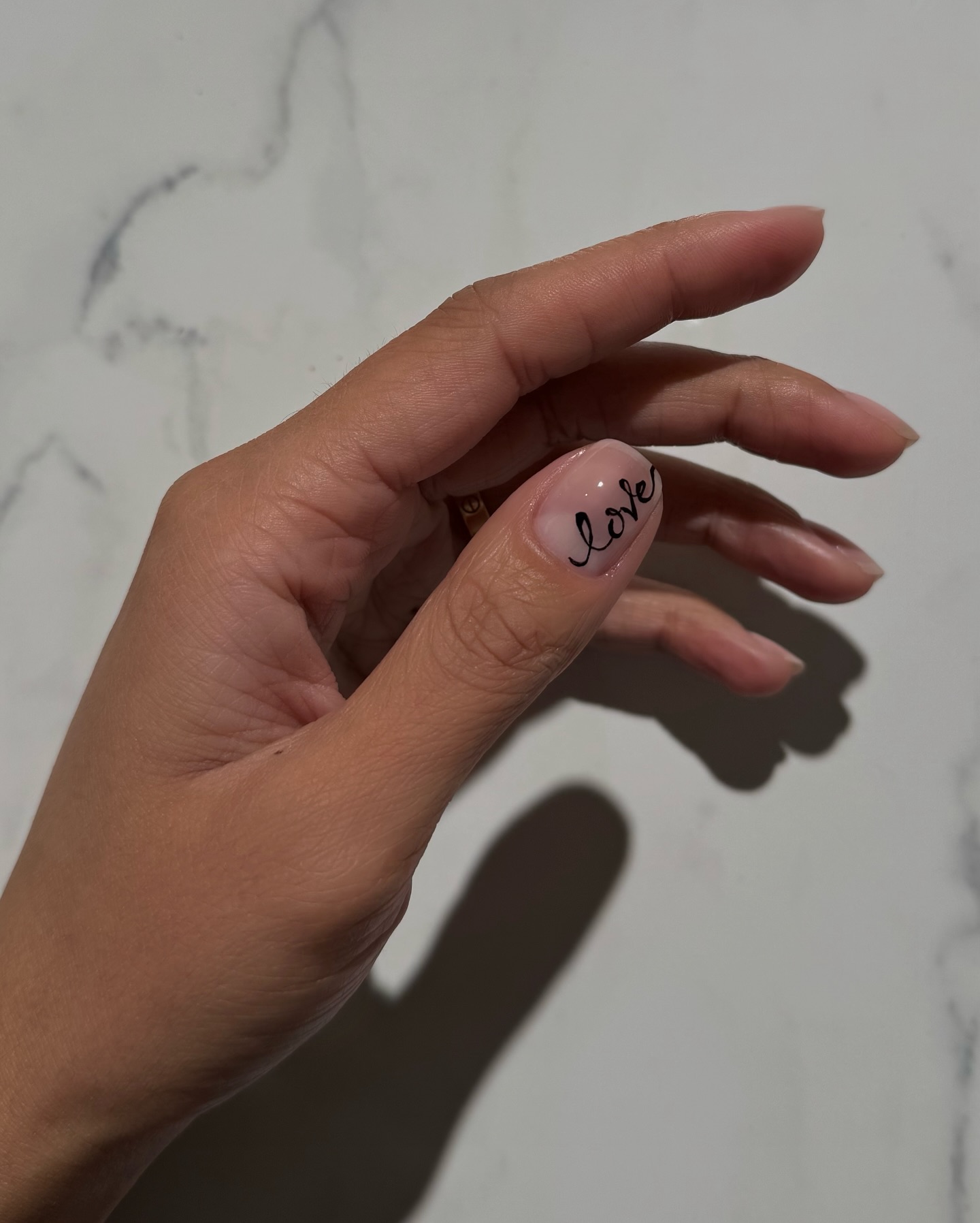 A manicure with the word "love" written in cursive by Iram Shelton