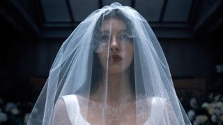Camila Morrone is shown in a wedding dress as Rachel Harkin in Netflix's Something Very Bad Is Going to Happen.