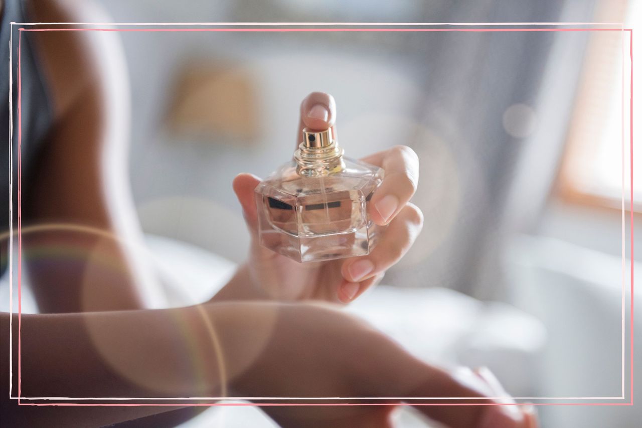 A close up of a woman spraying perfume on her wrist