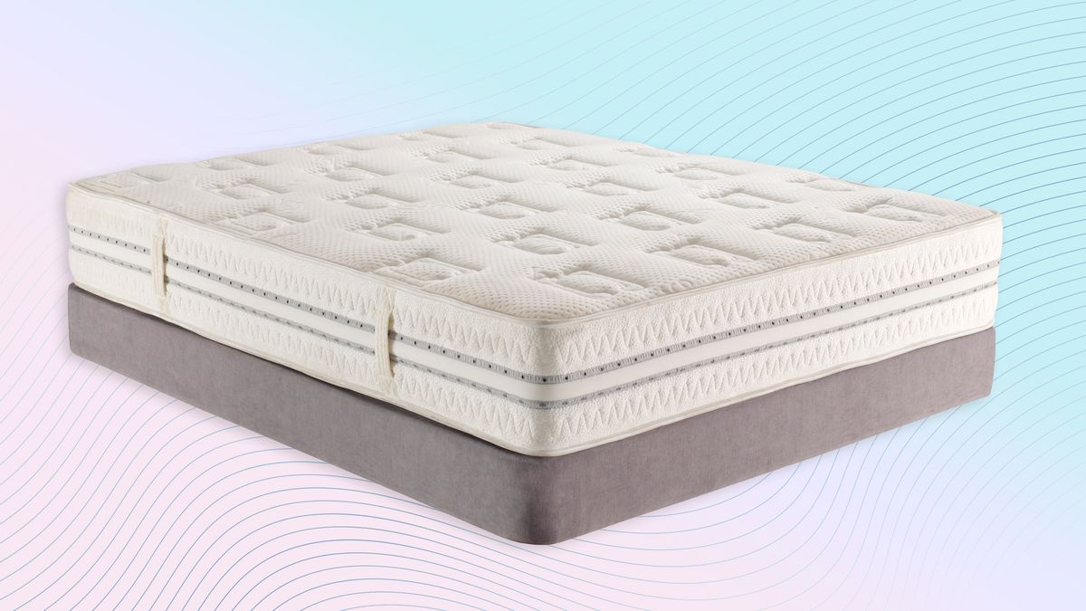 Image shows a white innerspring mattress on a grey box spring placed on a pink and blue ombre style background