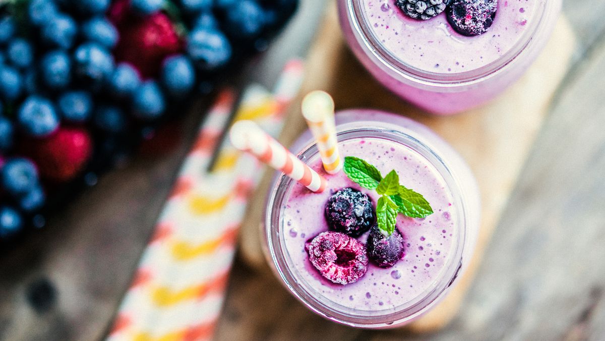 Aerial view of purple berry smoothie with straw