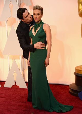 Actor John Travolta (L) and actress Scarlett Johansson attend the 87th Annual Academy Awards