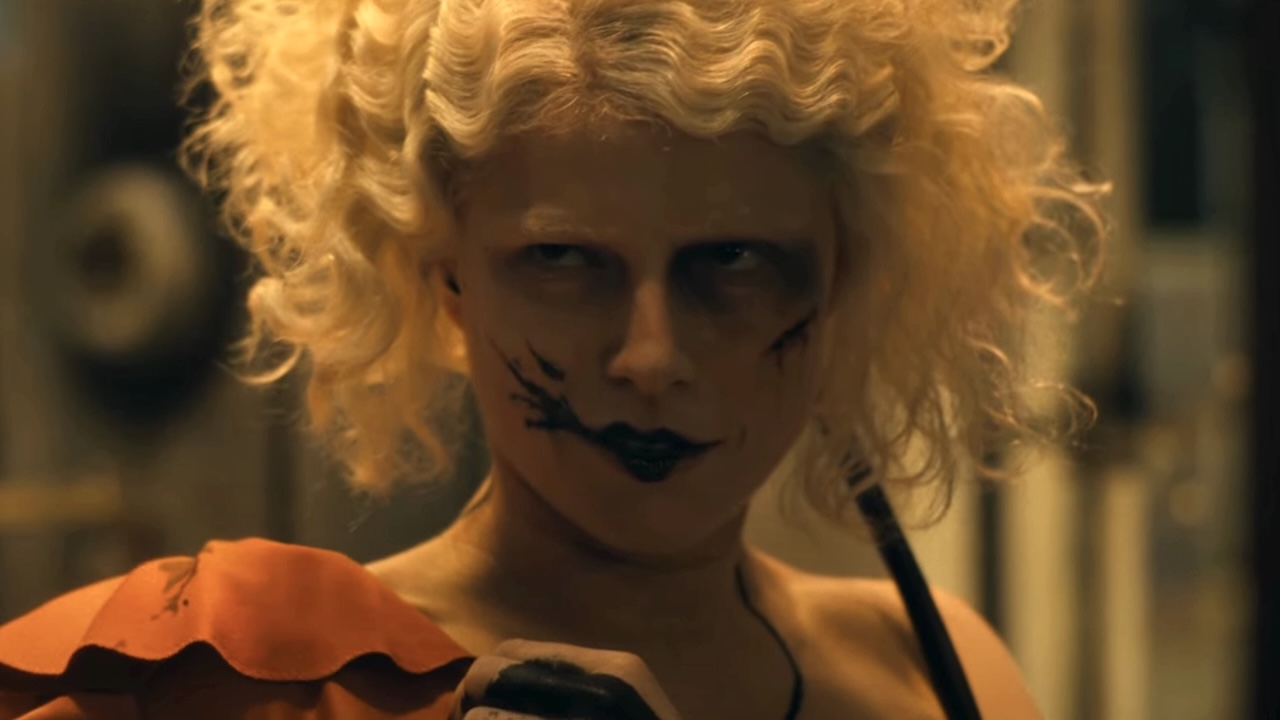 Jessie Buckley&#039;s as Frankenstein&#039;s bride in orange dress with blood smeared on the right side of her mouth