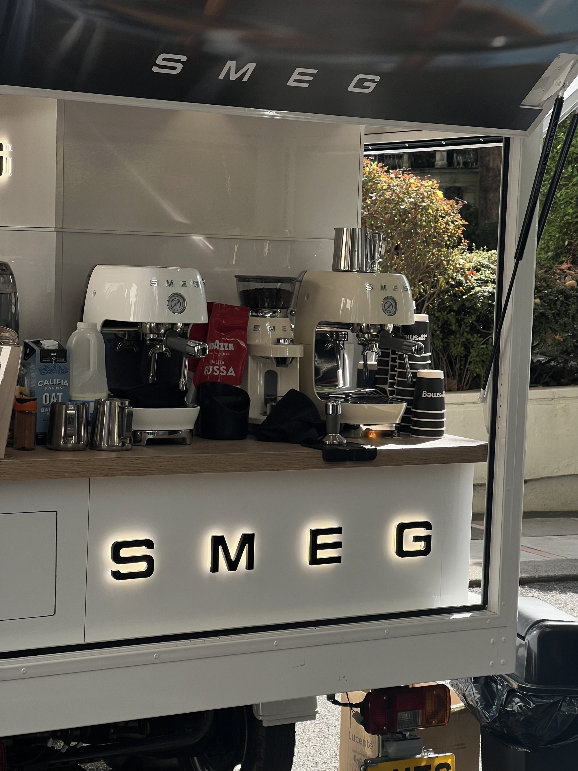 Image of a Smeg barista cafe cart with multiple of the new cold brew coffee machines on it. There are other Smeg products, like the Smeg coffee grinder on the cart, as well as coffee cups, milk jugs, and other cafe essentials.