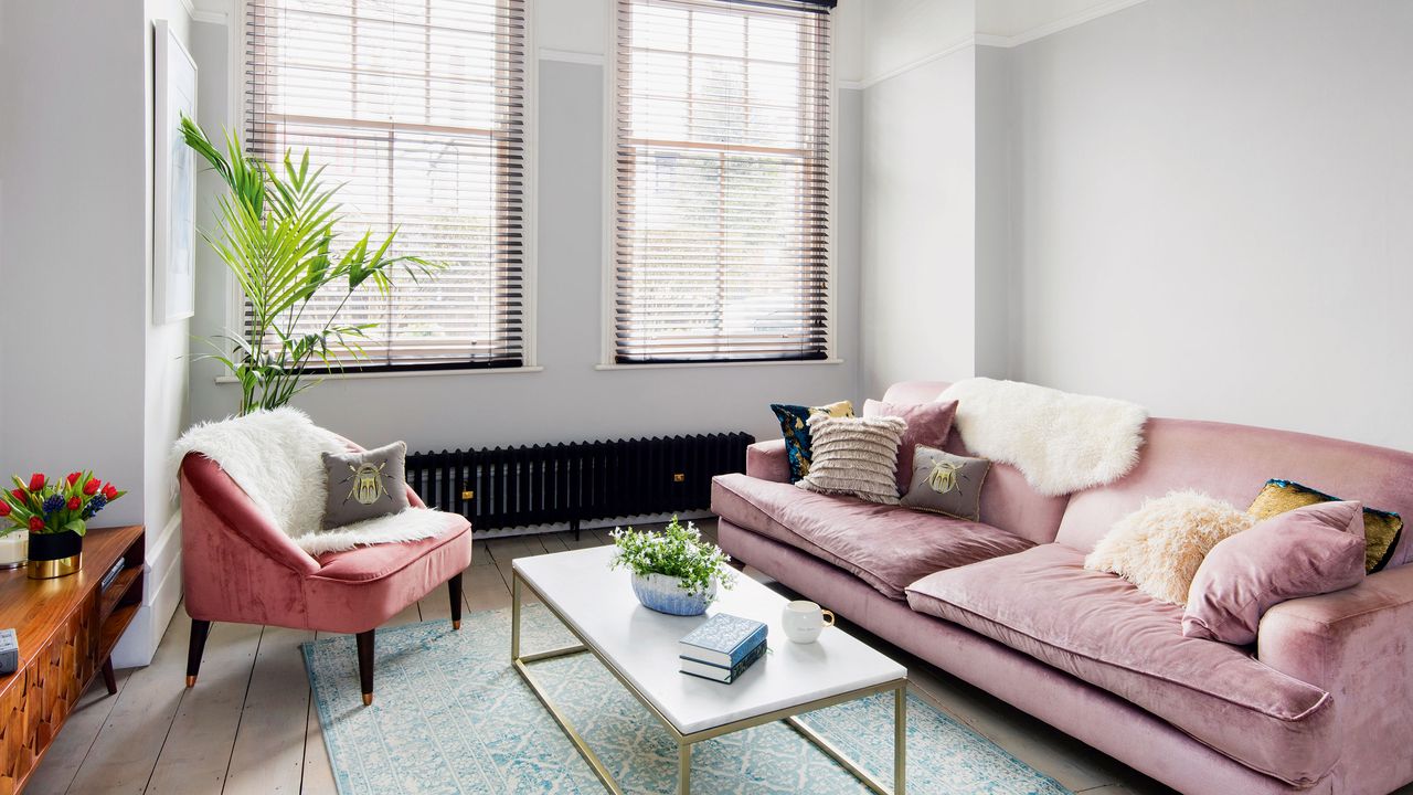 Black radiator in living room with pink sofa