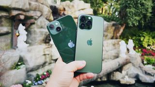 Alpine Green iPhone 13 Pro and Green iPhone 13 in front of Snow White fountain at Disneyland