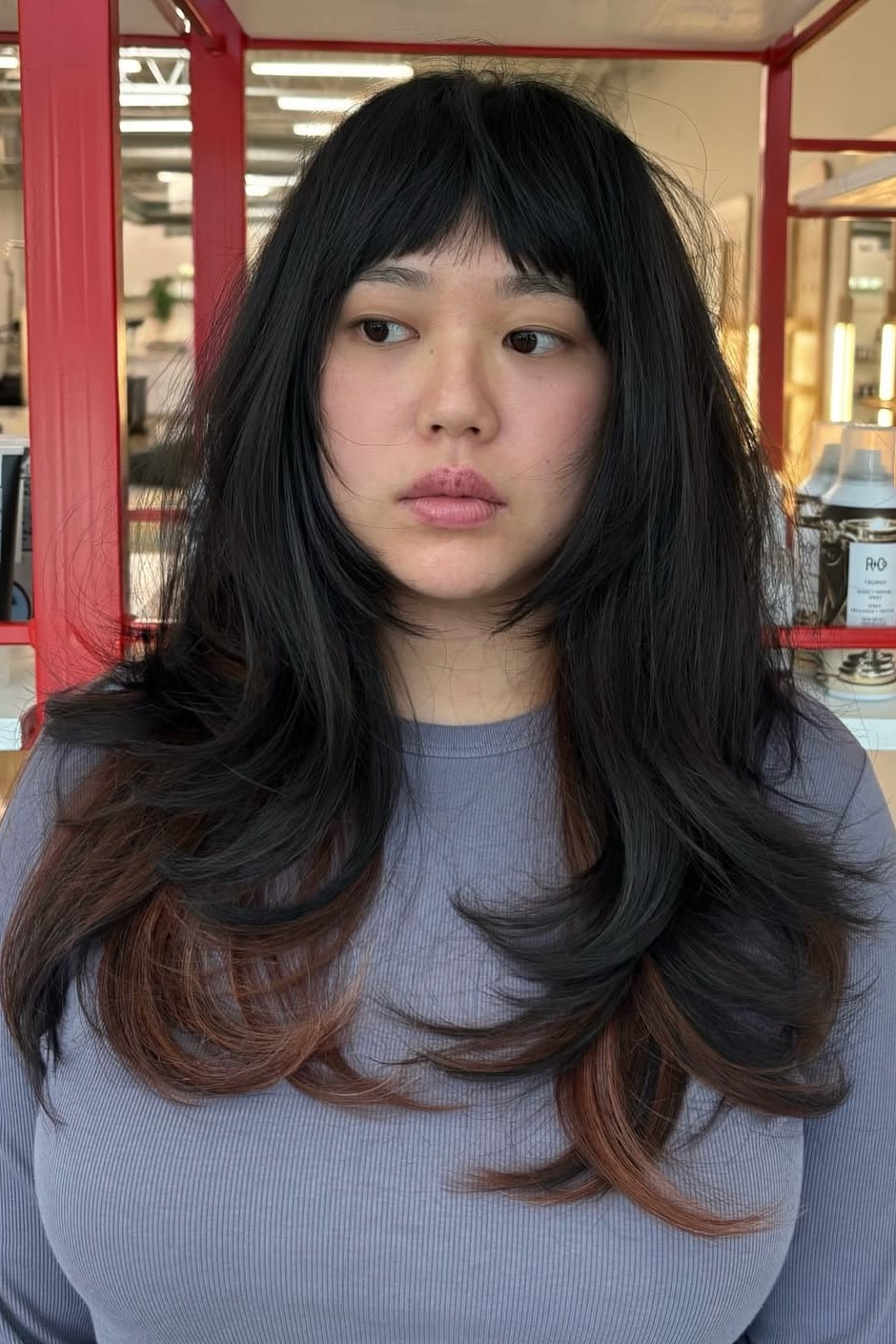 A model with their hair cut in long layers.
