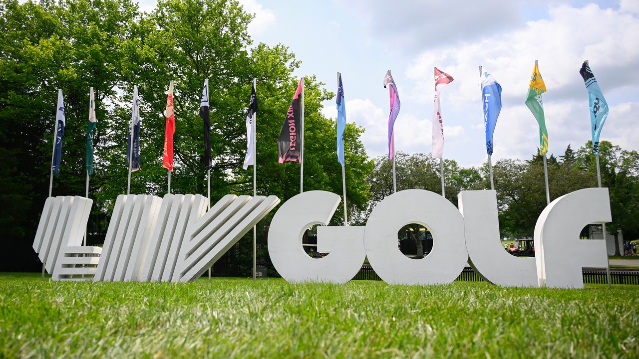 A LIV Golf sign with flags of the 13 teams in the background