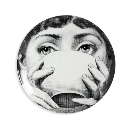 Plate wall art of a girl sipping a cup of tea.