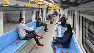 People sit on designated areas to ensure social distancing inside a light rapid transit train in Palembang, Indonesia, on March 20, 2020, amid concerns of the COVID-19 pandemic.