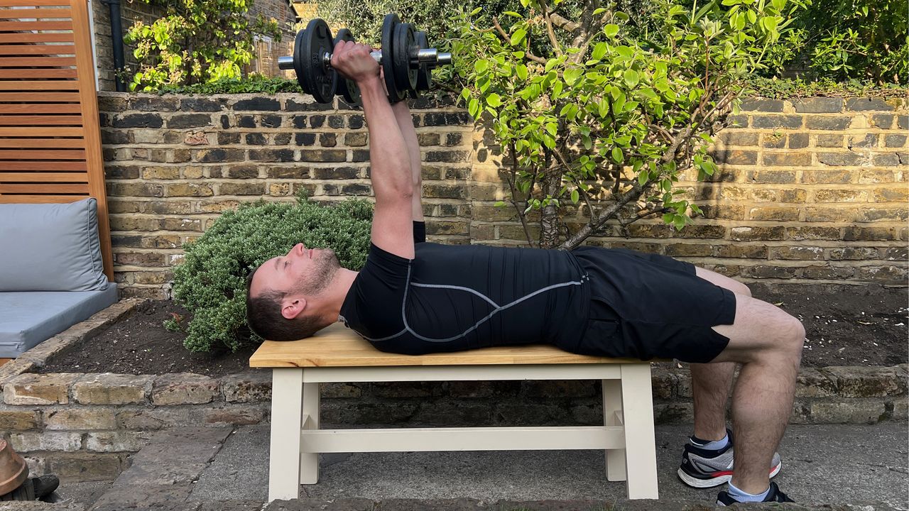 Man performing dumbbell bench press workout