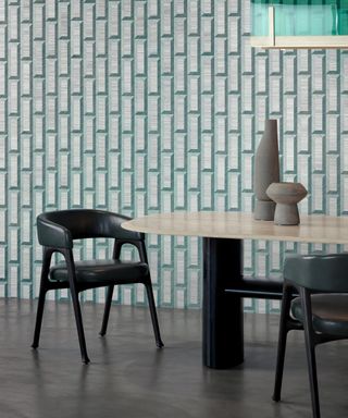 What is Bauhaus style, dining room with Bauhaus style wallpaper in jade and grey, black armchairs, black and blonde wood table, organic style vases