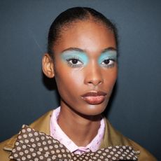 A model wearing bright blue eyeshadow