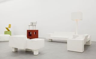 The show displays the development and the transition between the two recent bodies of work ’New Tribal Labyrinth’ and ’Neo-futurism. White models of two sofas, a chair and a floor lamp.