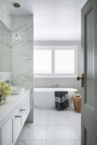 A bathroom with white tiles and grey grout lines