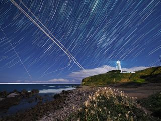 Star trails over a lighthouse