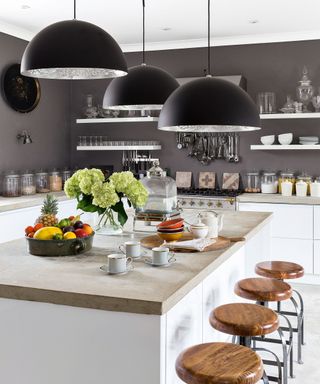 Kitchen wall lighting ideas with grey walls, a stone island and metal fixtures.
