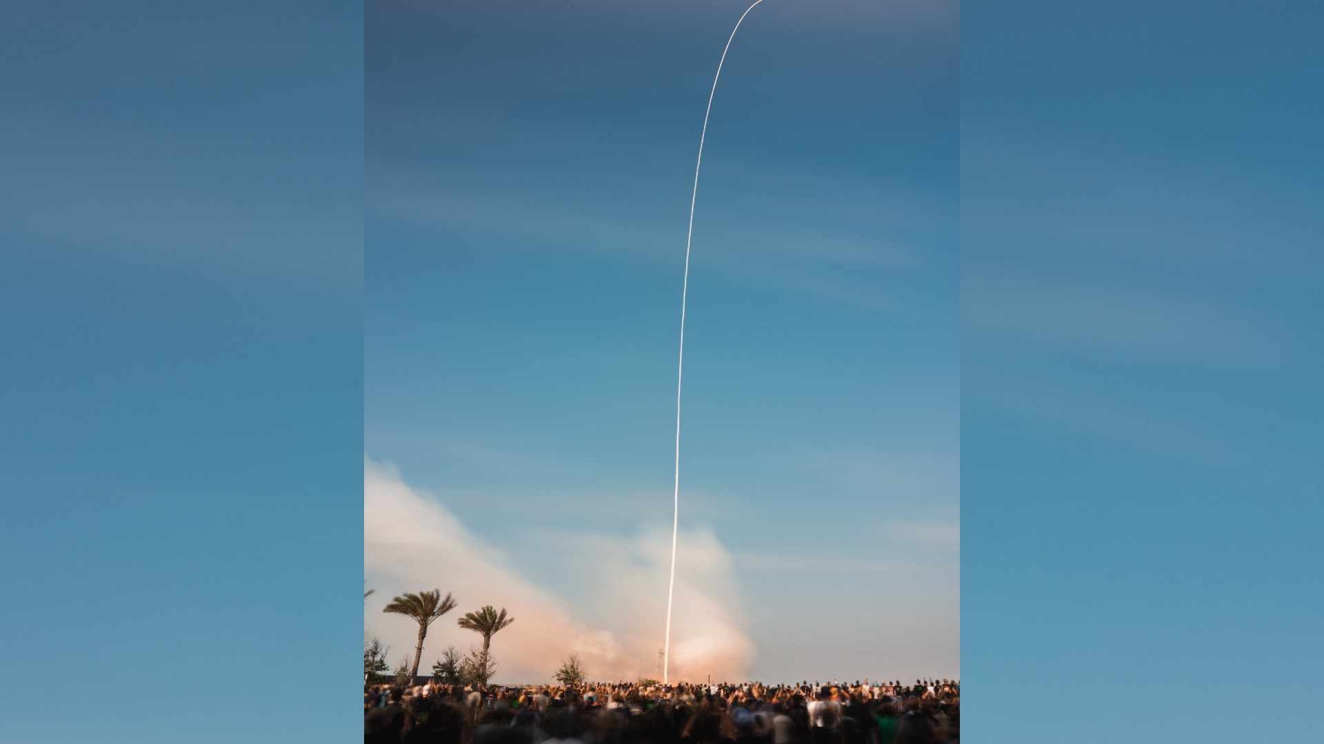 a large silver rocket launches above a plume of fire
