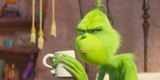 The Grinch holding a coffee cup and looking grinchy
